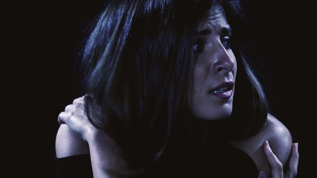 Woman alone at night on street scared feeling fear horror closeup slow motion