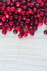 fresh cranberries on white wooden surface
