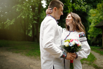  Beautiful bride and groom in the ukrainian style are standing w