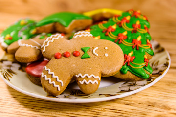 Plate with different christmas gingerbread cookies on wooden table