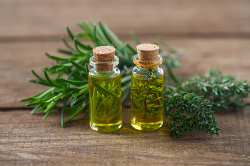 olive oil with herbs on wooden surface