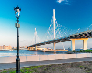 Embankment, a lantern and a bridge across the Neva of the Western High-Speed Diameter in St. Petersburg. Russia