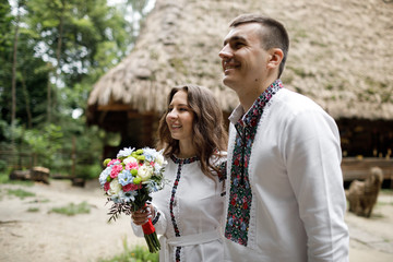  Beautiful bride and groom in the ukrainian style are standing w
