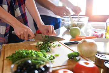 Young couple cooking together in the kitchen at home.