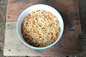 instant noodles  in blue bowl on the wooden background.