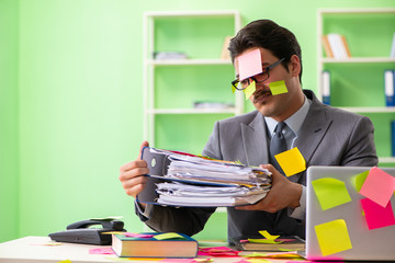 Businessman unhappy with many conflicting priorities sitting in 