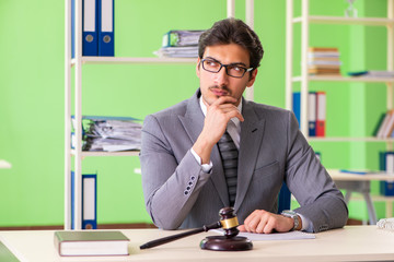 Young handsome lawyer working in the office 