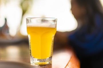 Glass of beer on restaurant table with blurred enjoy people eating background