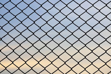 Fototapeta premium Steel mesh fence with beautiful sky background