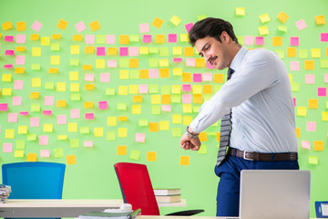 Man in the office with many conflicting priorities doing exercis