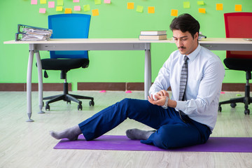 Man in the office with many conflicting priorities doing exercis