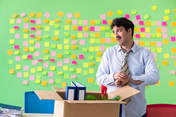 Man collecting his stuff after redundancy in the office with man
