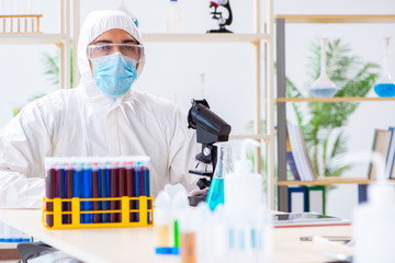 Young chemist student working in lab on chemicals