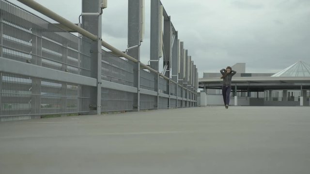young girl walk towards camera with a very cool attitude. Her hair blows in the wind
