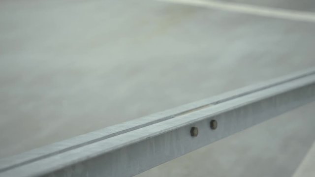 urban dancer walks on a grey concrete floor. Focus is set on concrete elements in front