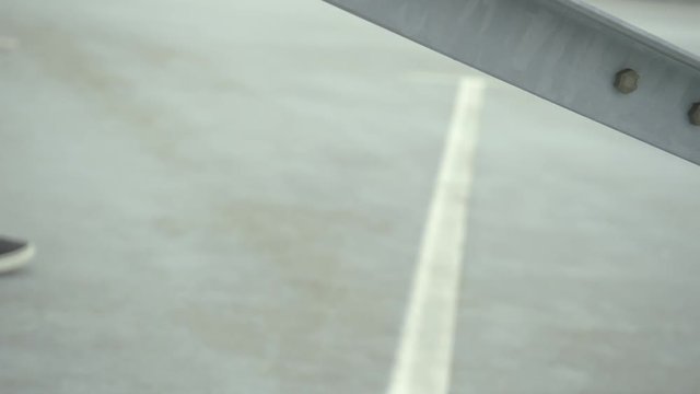 Hip hop girl walks and dancing on a grey concrete floor. Focus is set on concrete elements in front