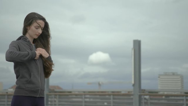 young female Urban dancer opens cool her hoody and throw it away on a windy day