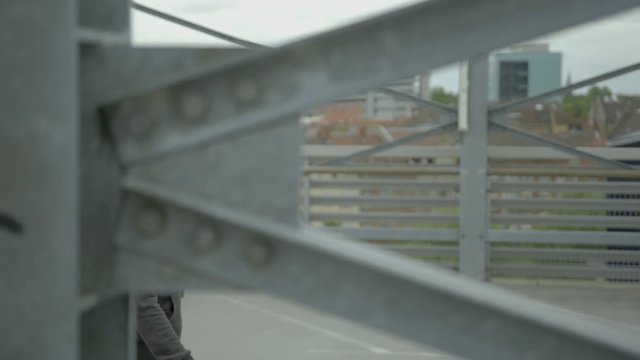 Young girl with a hoody walks very cool by on a concrete pier