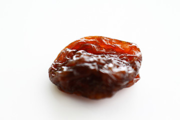 Close up raisin texture as background / A raisin is a dried grape. Raisins are produced in many regions of the world and may be eaten raw or used in cooking, baking, and brewing