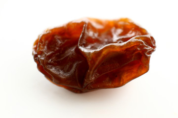 Close up raisin texture as background / A raisin is a dried grape. Raisins are produced in many regions of the world and may be eaten raw or used in cooking, baking, and brewing