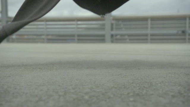 urban female dancer throws her hoody on a concrete floor