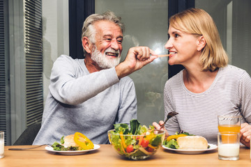 Senior couple enjoy eating  healthy breakfast together in the kitchen.Retirement couple concept
