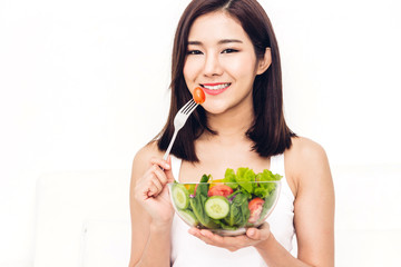 Happy woman eating and showing healthy fresh salad in a bowl.dieting concept.healthy lifestyle with green food