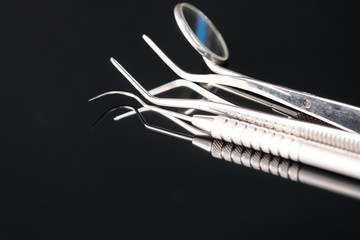 Dental tools use for dentist in the office or clinic. On the black background.