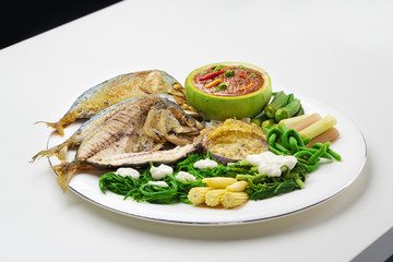 Fried mackerel with shrimp paste sauce and .boiled vegetables on white table.