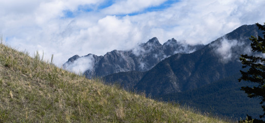 Morning mist rises above the Fairmont Ridge mountain peaks in British Columbia