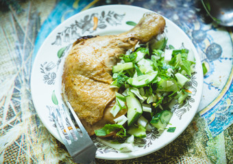 Roasted chicken leg with fresh summer salad. Selective focus.