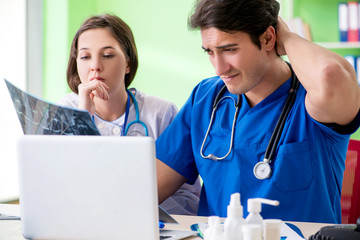 Woman and man gynecologists discussing medical case at the clini