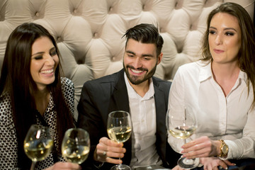 Group of young people celebrating and toasting with white wine
