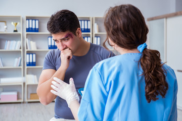 Young man visiting female traumatologist with black eye 