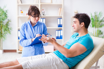 Obraz premium Doctor checking nerve reflexes with hammer