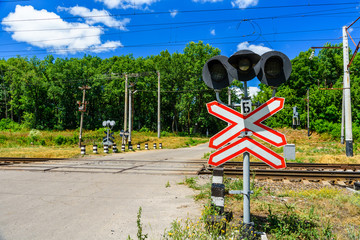 Railroad crossing sign and semaphore in front of the railroad crossing