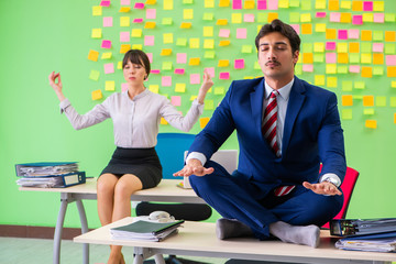 Man and woman in the office with many conflicting priorities in 