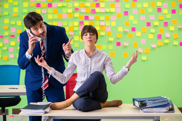 Man and woman in the office with many conflicting priorities in 