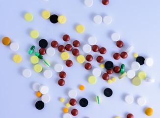 The medicine is out of the bottle on a white table..