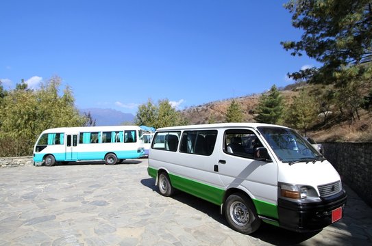 Two white vans at parking  space on the hill, Bhutan