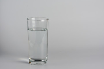 Glass with water on a white table..