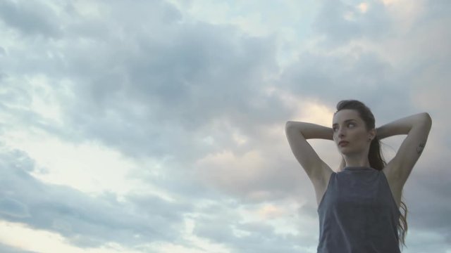 Potrait of Young dancer preparing hair in front a sunset blue sky, dancing slow