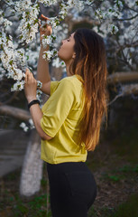 Girl smells blossom of tree