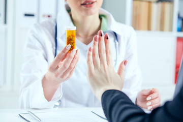 Female patient at the doctor appointment refuses to take prescribed medications, believes that they are useless and these biological drugs will only cause harm to his body.