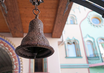 Obraz premium Ancient iron bell on the background of a wooden structure.