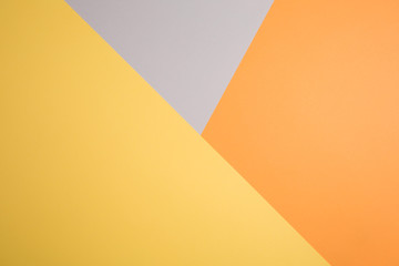 geometric paper background in autumn tones. corners and triangles of gray, yellow, orange colors.