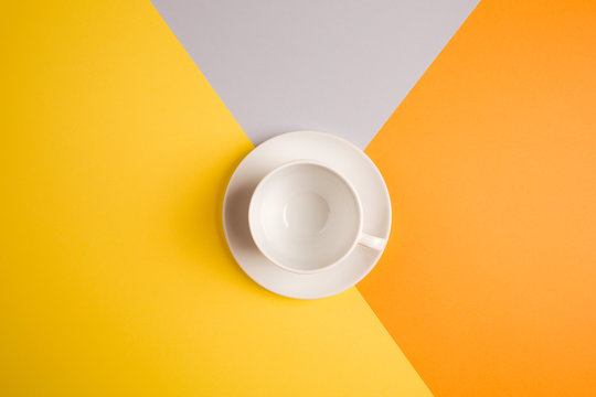 white empty coffee Cup on bright yellow-orange-beige-gray background. copy spase, flat lay. concept of autumn cafe menu