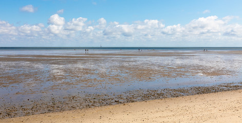 north sea beach with blue sky and clouds