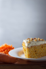Piece of carrot cake on plate with copy space on gray background
