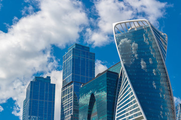 Fototapeta na wymiar Moscow, Russia, 08.14.2018. The reflection of the sky in towers-skyscrapers of Moscow-city. Towers of the Moscow business center against a cloudy blue sky